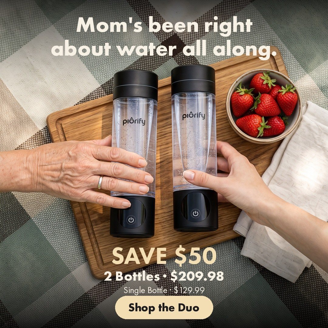 Two hands setting two bottles on a picnic board with strawberries